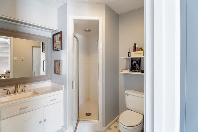 bathroom with vanity, toilet, a shower with door, and a textured ceiling