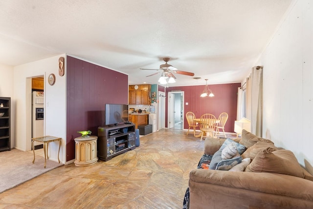 living room with ceiling fan with notable chandelier