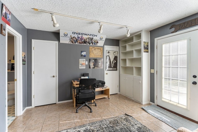 home office featuring light tile patterned flooring and a textured ceiling