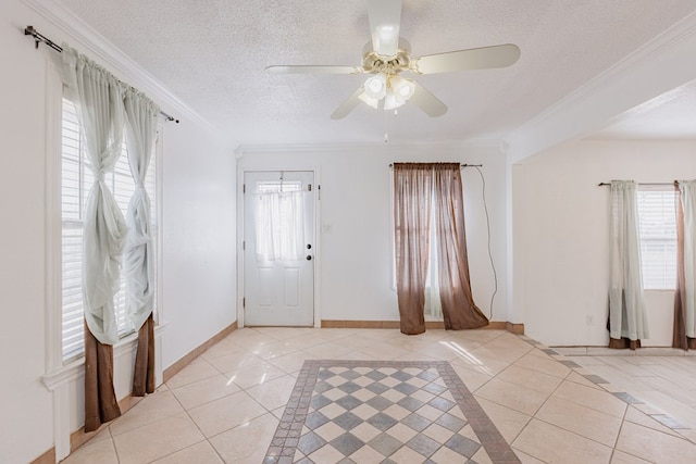 tiled entryway featuring ceiling fan, ornamental molding, and a textured ceiling