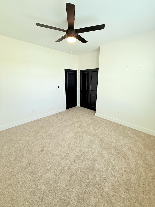 unfurnished room featuring ceiling fan and light colored carpet