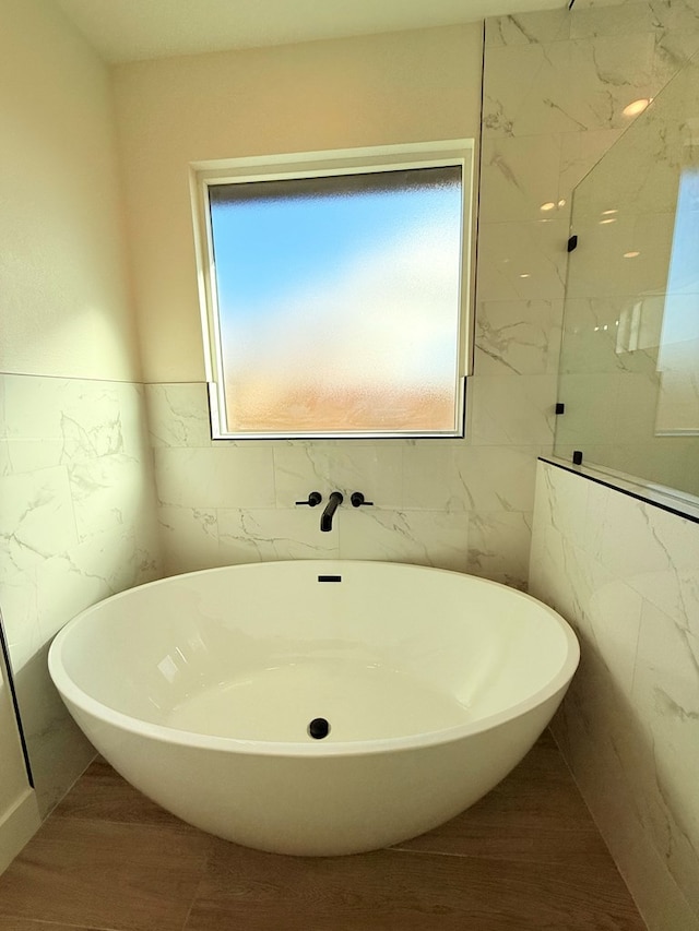 bathroom with a bath and tile walls