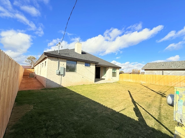 back of house featuring cooling unit and a lawn