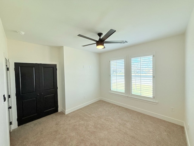 spare room with light carpet and ceiling fan