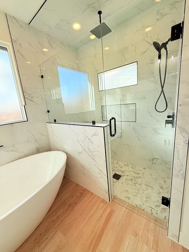 bathroom featuring independent shower and bath, tile walls, and hardwood / wood-style flooring