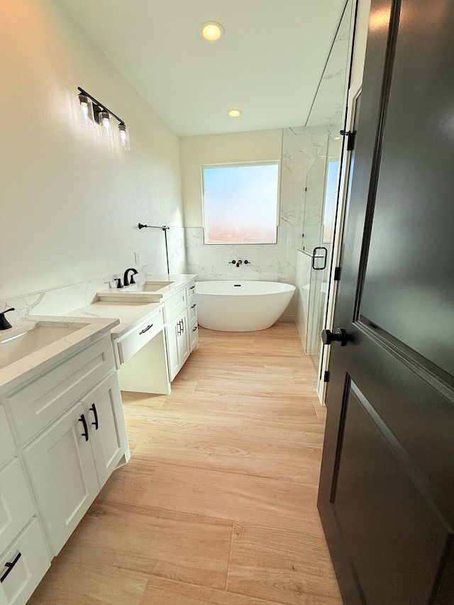 bathroom with hardwood / wood-style flooring, vanity, and independent shower and bath