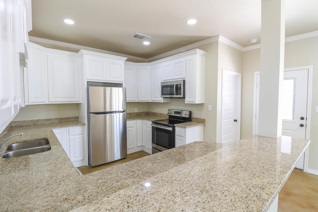 kitchen with white cabinets, stainless steel appliances, light stone countertops, and sink