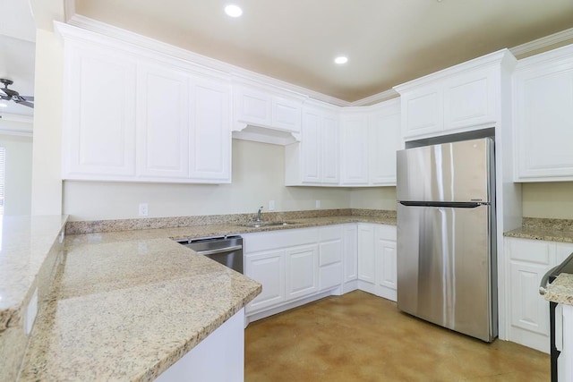 kitchen featuring sink, ceiling fan, light stone countertops, appliances with stainless steel finishes, and white cabinetry