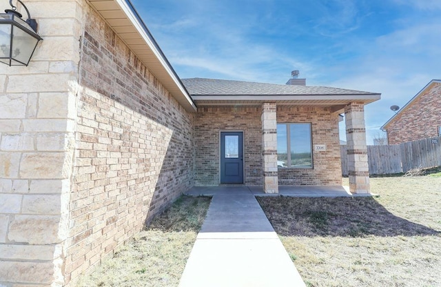 view of exterior entry with a patio area