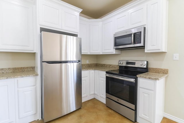 kitchen with white cabinetry, stainless steel appliances, and light stone counters