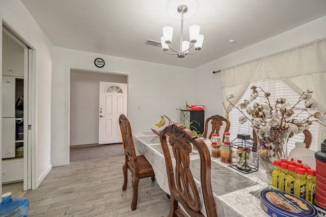 dining space featuring a notable chandelier and light hardwood / wood-style floors