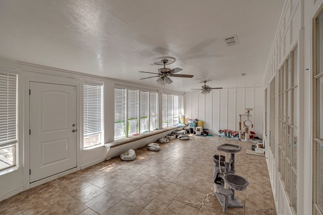 interior space with ceiling fan and a textured ceiling