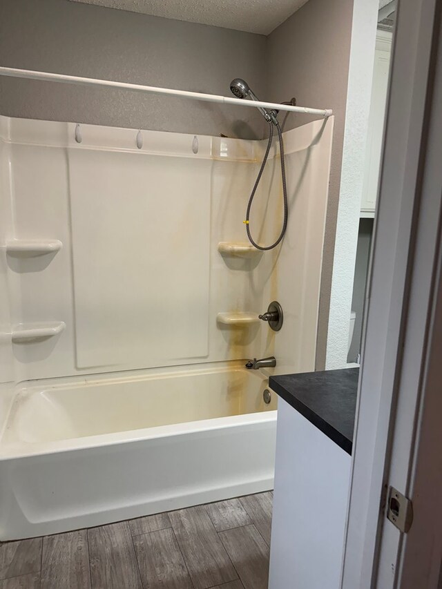 bathroom featuring vanity, shower / bath combination, a textured ceiling, and hardwood / wood-style flooring