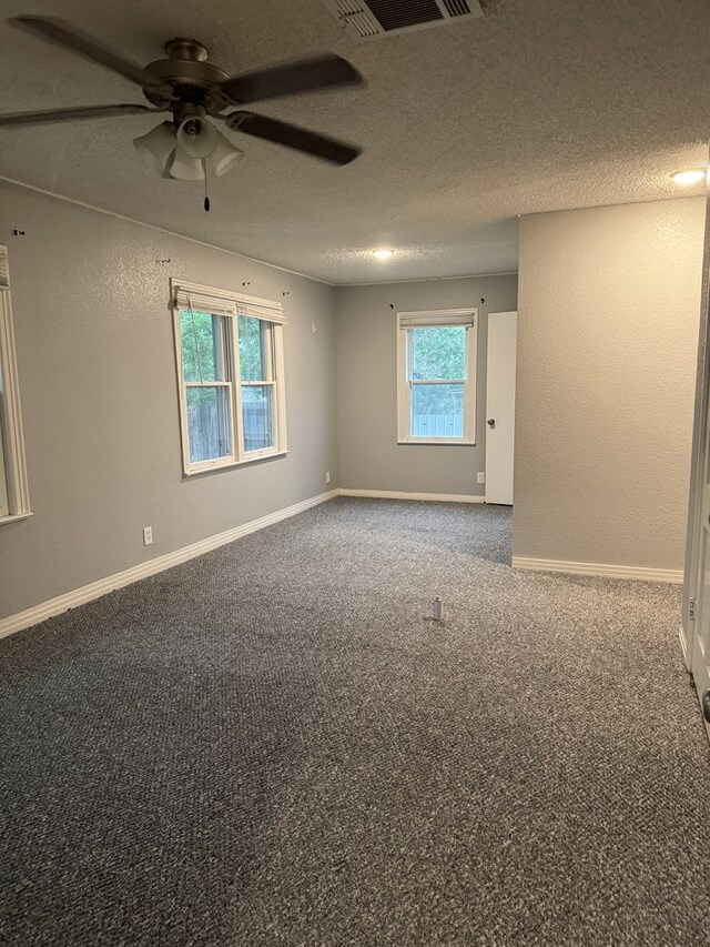 carpeted spare room with a textured ceiling and ceiling fan