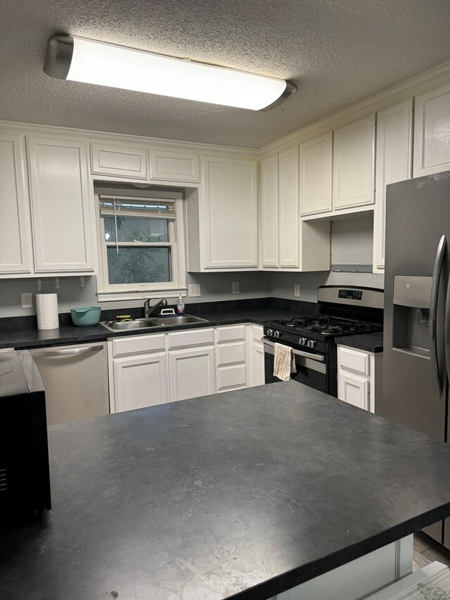 kitchen featuring white cabinetry, sink, a textured ceiling, and appliances with stainless steel finishes