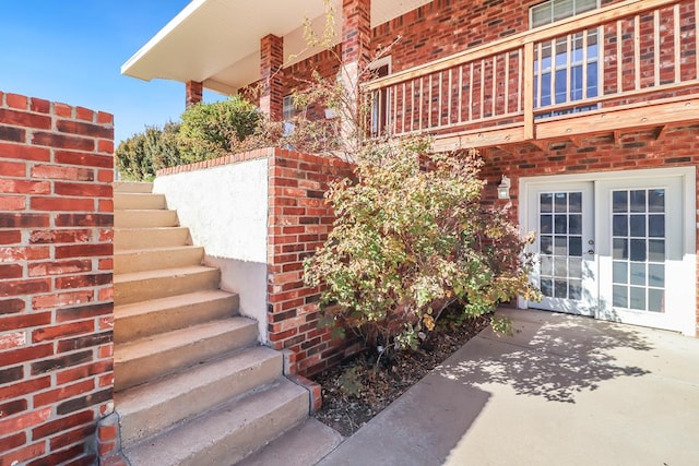 entrance to property featuring french doors, a balcony, and a patio area