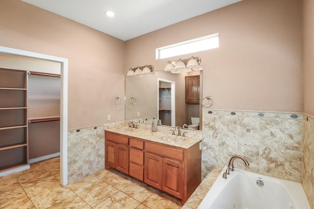 bathroom featuring vanity, a washtub, and tile walls