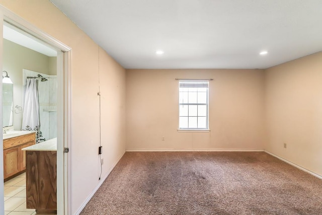 unfurnished room featuring light colored carpet and sink