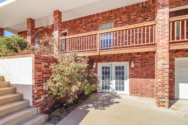 doorway to property with french doors, a balcony, and a patio area