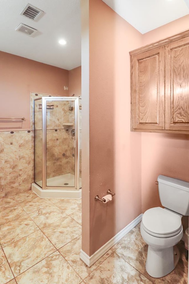 bathroom with an enclosed shower and toilet