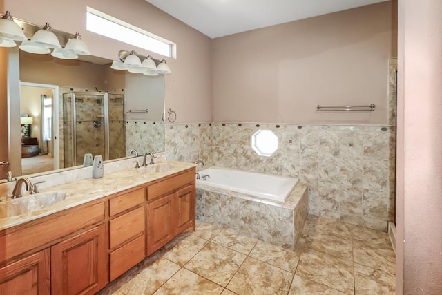 bathroom featuring tile patterned floors, vanity, shower with separate bathtub, and tile walls