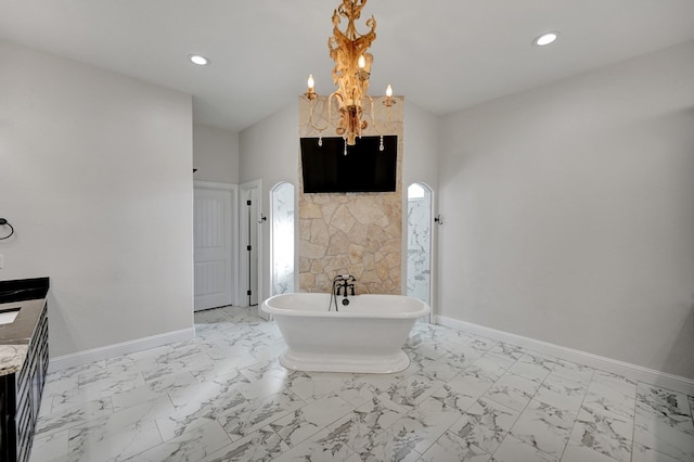 full bath with lofted ceiling, baseboards, marble finish floor, and a freestanding bath