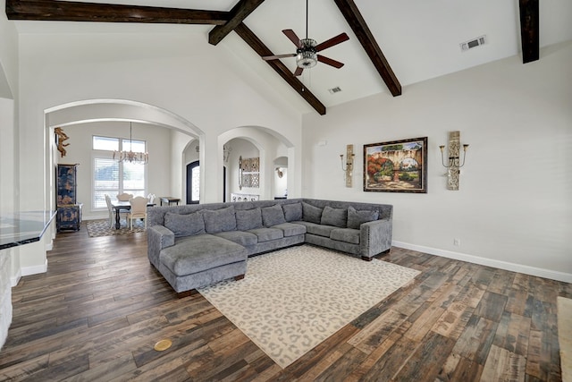 living area with visible vents, beam ceiling, dark wood-style floors, arched walkways, and high vaulted ceiling