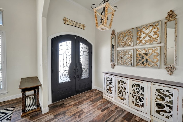 entryway featuring dark wood-style floors, french doors, arched walkways, and baseboards