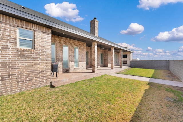 back of property featuring brick siding, a lawn, a patio, and a fenced backyard