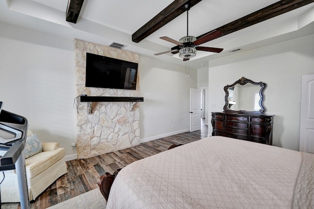 bedroom featuring visible vents, beam ceiling, baseboards, and wood finished floors