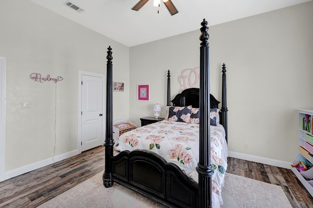 bedroom featuring ceiling fan, visible vents, baseboards, and wood finished floors