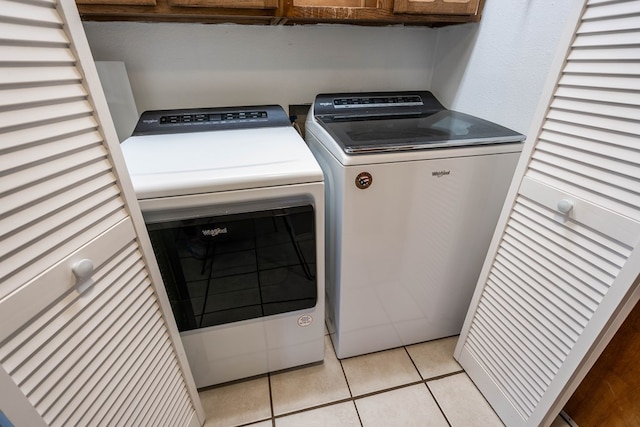 clothes washing area featuring independent washer and dryer and light tile patterned flooring