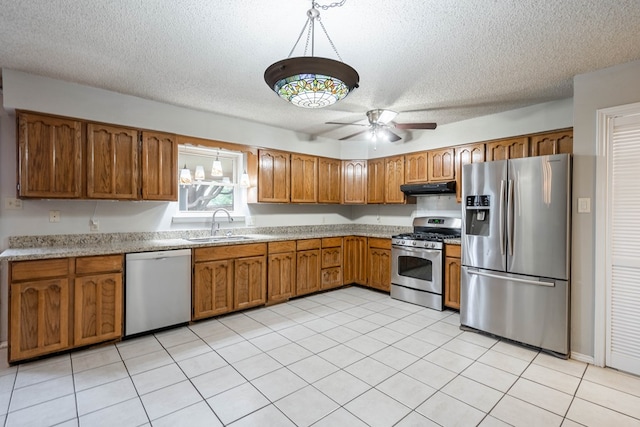 kitchen featuring sink, decorative light fixtures, a textured ceiling, and appliances with stainless steel finishes