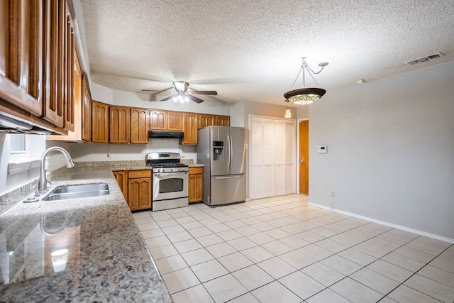 kitchen with appliances with stainless steel finishes, sink, light tile patterned floors, ceiling fan, and a textured ceiling