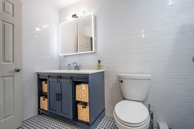 bathroom featuring tile walls, vanity, and toilet