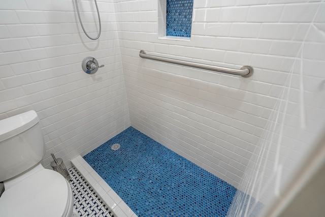 bathroom with toilet and tiled shower