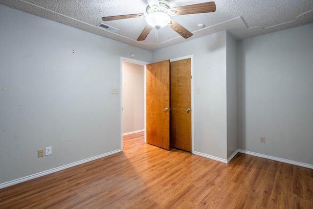 spare room featuring ceiling fan, a textured ceiling, and light hardwood / wood-style flooring