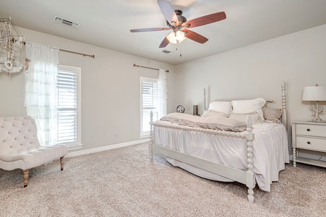 bedroom with carpet, visible vents, and multiple windows