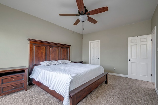bedroom with a closet, ceiling fan, light carpet, and baseboards