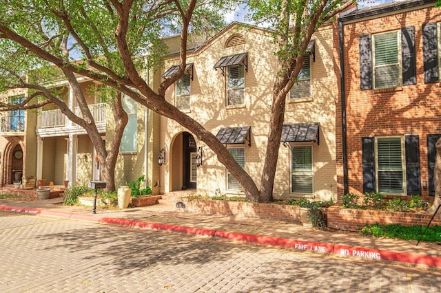 view of front of property featuring a balcony and brick siding