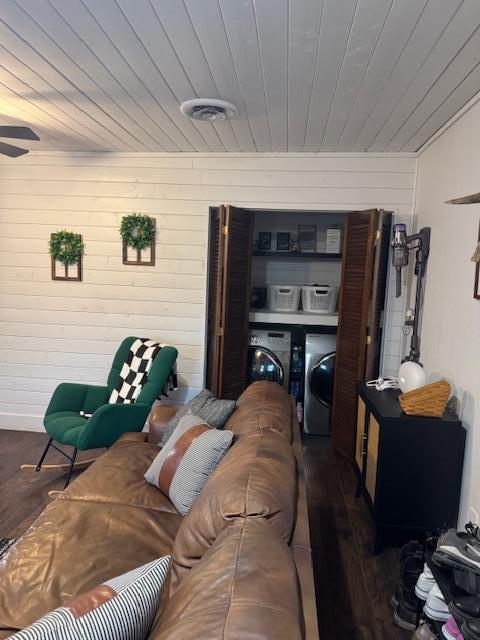 living room with dark hardwood / wood-style floors, wood walls, independent washer and dryer, and wooden ceiling