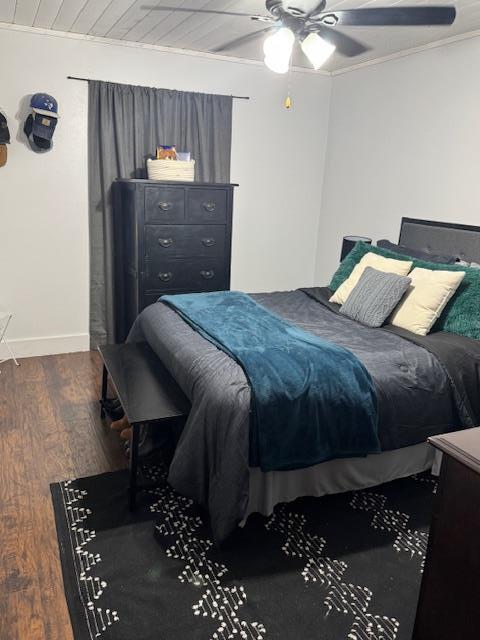 bedroom with ceiling fan, dark hardwood / wood-style floors, and ornamental molding