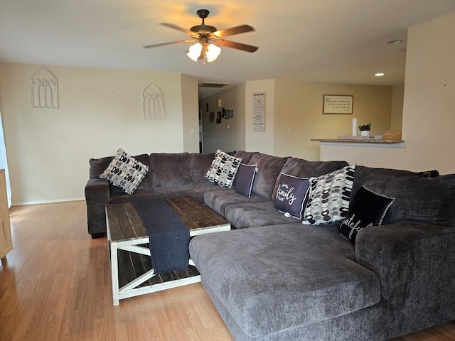 living room featuring hardwood / wood-style floors and ceiling fan