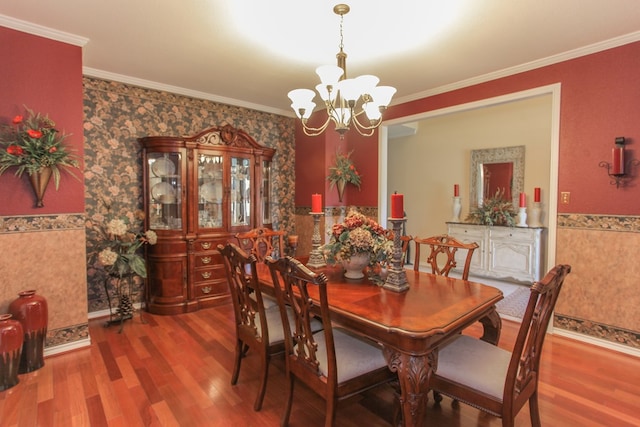 dining space with a chandelier, hardwood / wood-style flooring, and ornamental molding