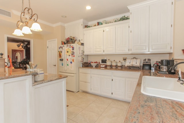 kitchen featuring pendant lighting, sink, crown molding, a notable chandelier, and white fridge