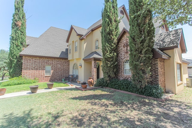 view of front of property with a front lawn and central AC unit