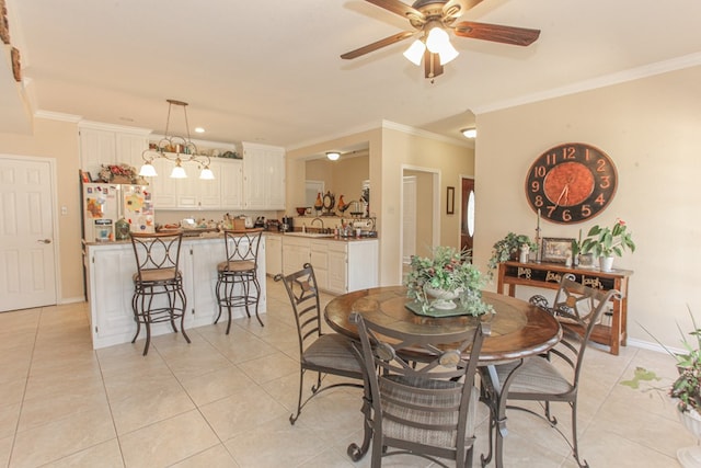 tiled dining room with ceiling fan, sink, and crown molding