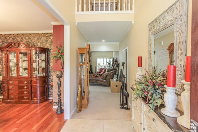 hall featuring ornamental molding and light hardwood / wood-style flooring