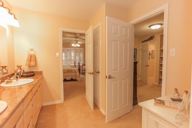 bathroom featuring ceiling fan, a textured ceiling, and vanity