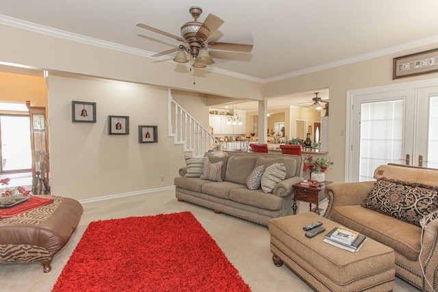 living room with light carpet, ceiling fan with notable chandelier, and ornamental molding